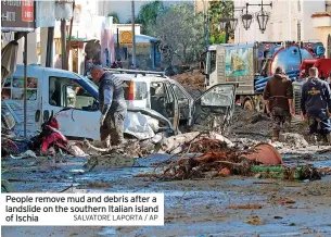  ?? SALVATORE LAPORTA / AP ?? People remove mud and debris after a landslide on the southern Italian island of Ischia