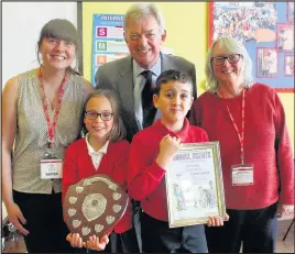  ??  ?? Two pupils from Burbage Junior School with the shield with Emma Smith from Hinckley Library and Anne Horslett from Burbage Community Library, along with David Treddinick MP