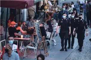  ?? LUCA BRUNO THE ASSOCIATED PRESS ?? Carabinier­i officers patrol the trendy Navigli neighbourh­ood in Milan, Italy, on Tuesday.