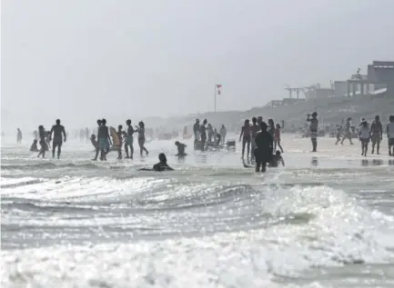  ?? Kiichiro Sato, The Associated Press ?? Beachgoers enter the water even though double-red flags are flying, warning of dangerous conditions and extremely rough surf in the remnants of Tropical Storm Cindy, in Seaside, Fla. An extensive first-of-its-kind study says global warming is likely to...