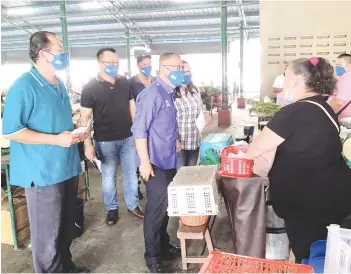  ??  ?? Chew (second left) meeting vendors in Sandakan Central Market yesterday.