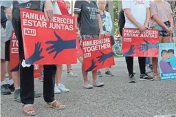  ??  ?? People hold signs that read “families belong together” in both English and Spanish during a vigil at Alice Hope Wilson Park in Brownsvill­e, Texas, on June 30 to advocate against the separation of migrant families at the U.S.-Mexico border.