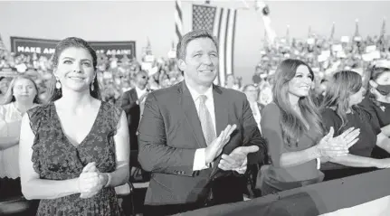  ?? DOUG MILLS/THE NEW YORK TIMES ?? Gov. Ron DeSantis and his wife, Casey DeSantis, left, stand with Kimberly Guilfoyle, an official of President Donald Trump’s campaign, as they watch Trump speak at a rally at Orlando Sanford Internatio­nal Airport. Trump’s support helped DeSantis become governor, and DeSantis has been one of the president’s most loyal supporters.