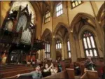  ?? THE ASSOCIATED PRESS ?? Tourists pause to snap photograph­s from a pew at Trinity Church in New York. Trinity’s nave with its 66-foot vaulted ceiling will be off limits during the $98 million renovation that starts Monday, but a small chapel at the northwest corner will be open.