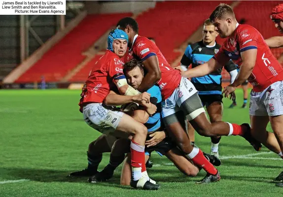  ?? ?? James Beal is tackled by Llanelli’s Llew Smith and Ben Raivalitia.
Picture: Huw Evans Agency