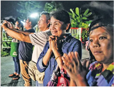  ??  ?? Onlookers gasp as ambulances deliver boys rescued from a flooded cave to a hospital – but rain is a serious concern for the remaining nine