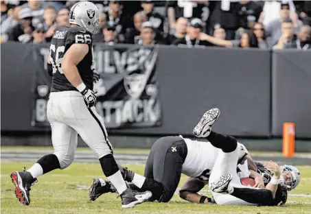  ?? Carlos Avila Gonzalez / The Chronicle ?? Carson Palmer hits the deck, sacked by Will Smith on the final play of the first half. Palmer was sacked three times in the game.