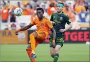  ?? MICHAEL WYKE — THE ASSOCIATED PRESS ?? Houston Dynamo defender Teenage Hadebe, left, brings down the ball in front of Portland Timbers forward Jarosław Niezgoda (11) during the second half of an MLS soccer match on Saturday in Houston.