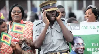  ?? PICTURE: AP ?? A policeman uses his cellphone in Zimbabwe where there has been an outcry over the hiking of data prices.