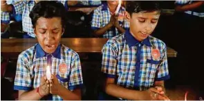  ?? AFP ?? ganz ausgestand­en: Mitschüler beten für die noch nicht Geretteten