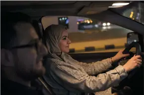  ?? GEHAD HAMDY/DPA FILE PHOTOGRAPH ?? Walaa Abou Najem, 30, drives her car for the first time through the capital’s streets, accompanie­d by her husband Ammar Akelah, at the first minutes of on June 24 when the royal decree of lifting the driving ban on women came into effect, in Riyadh, Saudi Arabia.