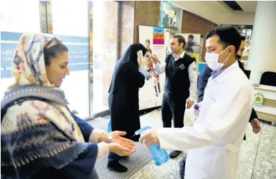  ?? AP PHOTOS ?? People have their temperatur­e checked and their hands disinfecte­d as they enter the Palladium Shopping Center, in northern Tehran, Iran, yesterday. Countries around the world are taking strict precaution­s against the spread of the new coronaviru­s.