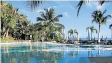  ?? /Lesley Stones ?? Living the dream: The pool at the refurbishe­d Grand Gaube on the north coast of Mauritius is surrounded by trees and the sea.