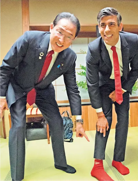  ?? ?? Rishi Sunak impressed Fumio Kishida, Japan’s prime minister, during dinner in Hiroshima by wearing the socks of Mr Kishida’s baseball team, Hiroshima Toyo Carp