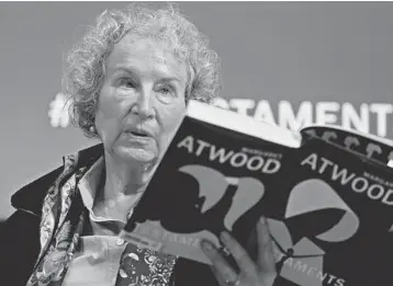  ?? ALASTAIR GRANT/AP ?? Author Margaret Atwood holds a copy of her book “The Testaments” during a 2019 news conference in London.