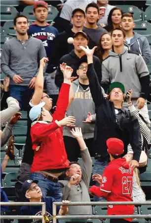  ?? JON DURR/GETTY IMAGES ?? Fans try to catch Mike Trout’s home-run ball in the first inning at Guaranteed Rate Field. Trout hit another homer in the third inning off James Shields and had five hits and five RBI.