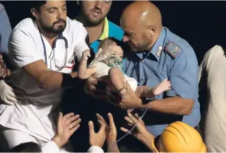  ?? AP ?? Rescuers pull out seven-month boy Pasquale from the rubble of a collapsed building in Casamiccio­la, on the island of Ischia, near Naples, Italy, a day after a 4.0-magnitude quake hit the Italian resort island yesterday.