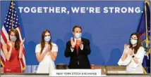  ?? NYSE VIA THE NEW YORK TIMES ?? New York Gov. Andrew Cuomo and New York Stock Exchange President Stacey Cunningham (right) applaud the reopening of the NYSE after Cuomo rang the opening bell Tuesday.