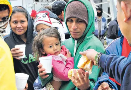  ?? EFE ?? Grupos de personas de la segunda caravana migrante reciben comida en el deportivo Jesús Martínez ‘Palillo’, en Ciudad de México.