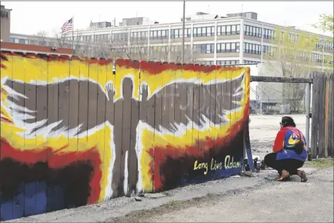  ?? SHAFKAT ANOWAR/AP ?? ANDREA FERNANDA SERRANO KNEELS AS SHE PAYS her respects to the site where 13-year-old Adam Toledo was shot by police now marked with a mural in the Little Village neighborho­od of Chicago on Friday, a day after the body camera video release of fatal police shooting of the boy.