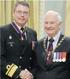  ?? JOHN MAJOR / POSTMEDIA NEWS FILES ?? Former Gov. Gen. David Johnston shakes hands after bestowing the honour of Commander of the Order of Military Merit to Norman in 2013.