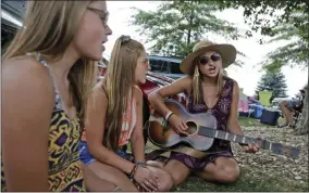  ?? SETH WENIG - ASSOCIATED PRESS ?? The Lescinski sisters, Kristi, 19, right, Jaime, 17, center, and Emily, 13, sing together in the parking lot while while waiting for the gates to open at a Woodstock 50th anniversar­y event in Bethel, N.Y., on Thursday.