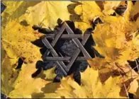  ?? (AP/dpa/Martin Schutt) ?? Autumn leaves lie on a gravestone with a small Star of David on Tuesday during a commemorat­ion of the November pogroms of 1938 by the Jewish Regional Community at the Jewish Cemetery in Erfurt, Germany.