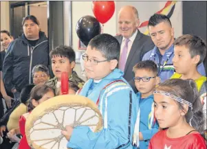  ?? ELIZABETH PATTERSON/CAPE BRETON POST ?? Eskasoni students sing the Honour Song during the grand opening of the Eskasoni Health Centre on Friday, while MP Mark Eyking, back centre left, and Eskasoni Chief Leroy Denny, back centre right, listen intently.