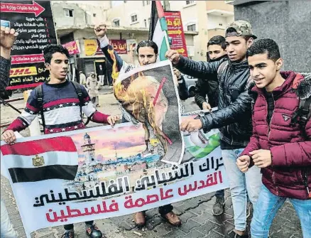  ?? SAID KHATIB / AFP ?? Jóvenes palestinos queman una imagen de Donald Trump en el sur de la franja de Gaza