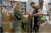  ?? AP ?? Volunteer Tetyana Khimion sorts out supplies for a Ukrainian soldier at a volunteer centre in Slovyansk in Ukraine’s Donetsk region yesterday.