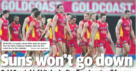  ?? Picture: Chris Hyde/Getty ?? DEJECTED: Co-captain Jarrod Witts leads his players from the field at Metricon Stadium after the firstround loss to Port Adelaide.
GREG DAVIS