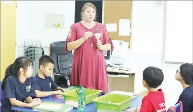  ?? Photograph­s courtesy of Amber Harrison ?? Harrison addresses Chinese students in her classroom at the Diligence & Delight Learning Center in Beijing, China.