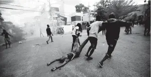  ??  ?? Demonstrat­ors drag the body of a fellow protester towards the police as a form of protest, after police shot into the crowd in which he died, during a demonstrat­ion demanding the resignatio­n of Haitian President Jovenel Moise near the presidenti­al palace in Port-au-Prince, Haiti, on February 12.