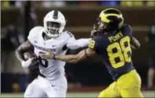  ?? CARLOS OSORIO — THE ASSOCIATED PRESS ?? Michigan State safety David Dowell (6) stiff arms Michigan wide receiver Grant Perry (88) after intercepti­ng a pass during the second half of the Spartans’ 14-10 victory over the Wolverines Saturday night in Ann Arbor, Mich.