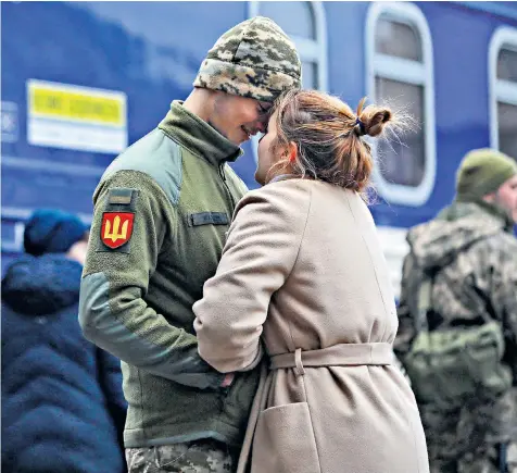  ?? ?? A Ukrainian serviceman bids farewell to his girlfriend at the railway station in the western city of Lviv before travelling east to Kyiv, where Russian troops are also heading