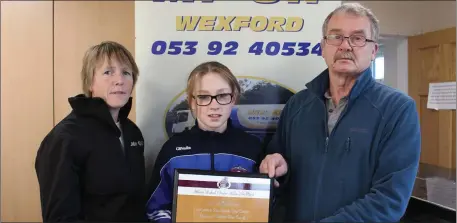  ??  ?? Emma McCarthy of St. Killian’s receives her athlete of the month award from Marie Mooney of Mr Oil, and Paddy Morgan (Chairman).