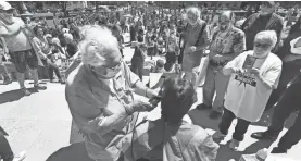  ?? AP ?? Barber Karl Manke gives a free haircut on the steps of the Michigan Capitol.