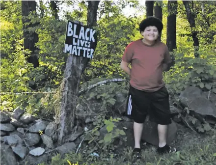  ?? BY RACHEL NEEDHAM ?? Dominic Wilson stands next to his homemade Black Lives Matter sign at the end of his driveway on Ben Venue Road in Flint Hill on June 9.