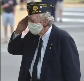  ?? PETE BANNAN - MEDIANEWS GROUP ?? Above, U.S. Air Force veteran George Clarke salutes during the playing of Taps at the Radnor Memorial Day service.
At left, those in attendance at the Radnor Memorial Day service practice social distancing.