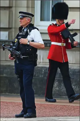  ??  ?? Protection: An armed officer outside Buckingham Palace yesterday