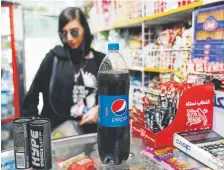  ?? Photos by Ebrahim Noroozi, The Associated Press ?? An Iranian customer buys Pepsi at a grocery store in Tehran, Iran.