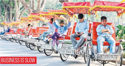  ?? Picture: AFP ?? Cycle rickshaw drivers wait for customers in Hanoi yesterday.