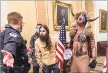  ?? Manuel Balce Ceneta / Associated Press file photo ?? Supporters of President Donald Trump, including Jacob Chansley, right with fur hat, are confronted by U.S. Capitol Police officers outside the Senate chamber inside the Capitol during the Capitol riot in Washington on Jan. 6, 2021.