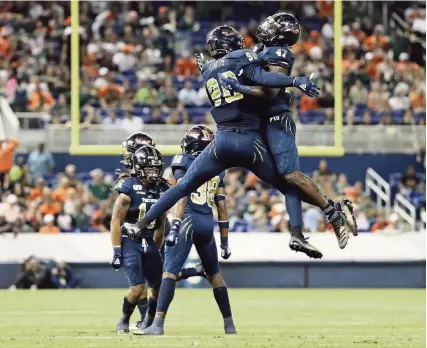  ?? AL DIAZ adiaz@miamiheral­d.com ?? FIU defensive lineman Noah Curtis (90) and linebacker Chris Whittaker (47) celebrate after stopping Miami in the second quarter of Saturday night’s game at Marlins Park.