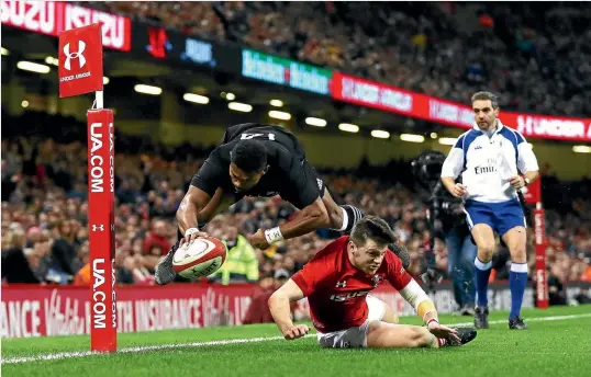  ?? PHOTO: GETTY IMAGES ?? Waisake Naholo, one half of an impressive All Blacks wing duo, dives over spectacula­rly ahead of Steff Evans for one of his two tries in the win over Wales.