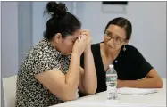  ??  ?? AP PHOTO BY STEVEN SENNE A mother from Guatemala, left, identified only by initials L.J., who was separated from her two children after entering the U.S. in May, receives support from translator Brenda Quintana, right, after speaking to reporters about the separation during a news conference, Thursday, Sept. 6, in Boston.