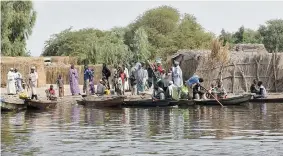  ?? SIA KAMBOU/AFP/Getty Images ?? People stand on the banks of Lake Chad in the village of Ngouboua. Nigeria’s Boko Haram rebels carried out their first attack Feb. 13 inside neighbouri­ng Chad, targeting a village on the shores of Lake Chad as part of a widening insurgency that has...