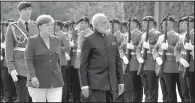  ?? AP/ MICHAEL SOHN ?? German Chancellor Angela Merkel welcomes India Prime Minister Narendra Modi to Berlin on Tuesday with a military honor guard. Modi said he welcomed a stronger global role for the European Union.