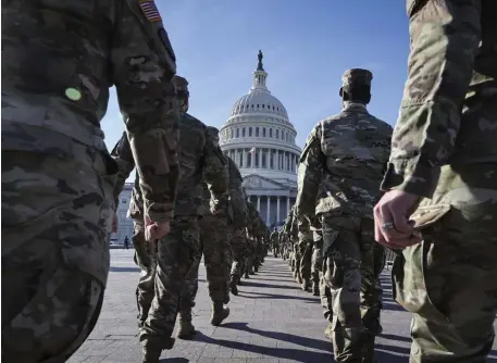  ?? Ap ?? BACK IN BUSINESS: National Guard members march outside the Capitol on Friday. After being exiled to a parking garage, troops have been allowed back inside the Capitol.