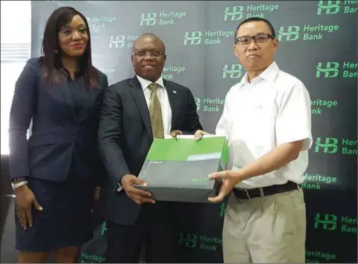  ??  ?? L-R: Executive Director; Retail & SME Bank,Mrs. Adaeze Udensi; Executive Director Business Banking, Jude Monye; who both represente­d the MD/CEO of Heritage Bank Plc, Ifie Sekibo; presenting a gift to the General Manager, Biase Plantation­s Limited...